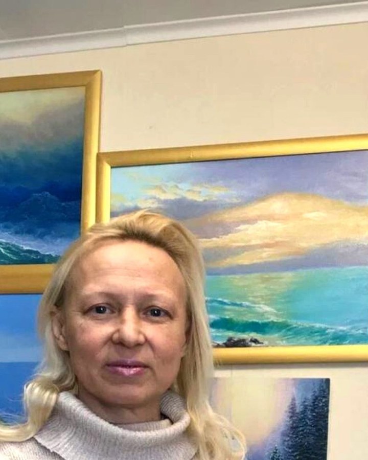 Наталья Мельничук на фоне своих картин